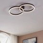 Moderne LED-Deckenleuchte Amandolo von Eglo, schwarz, mit zwei verschlungenen Ringen und RGB-Hintergrundbeleuchtung.