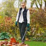 Frau nutzt Bosch Akku-Laubbläser UniversalLeafBlow 18V zum Laubreinigen im Garten.