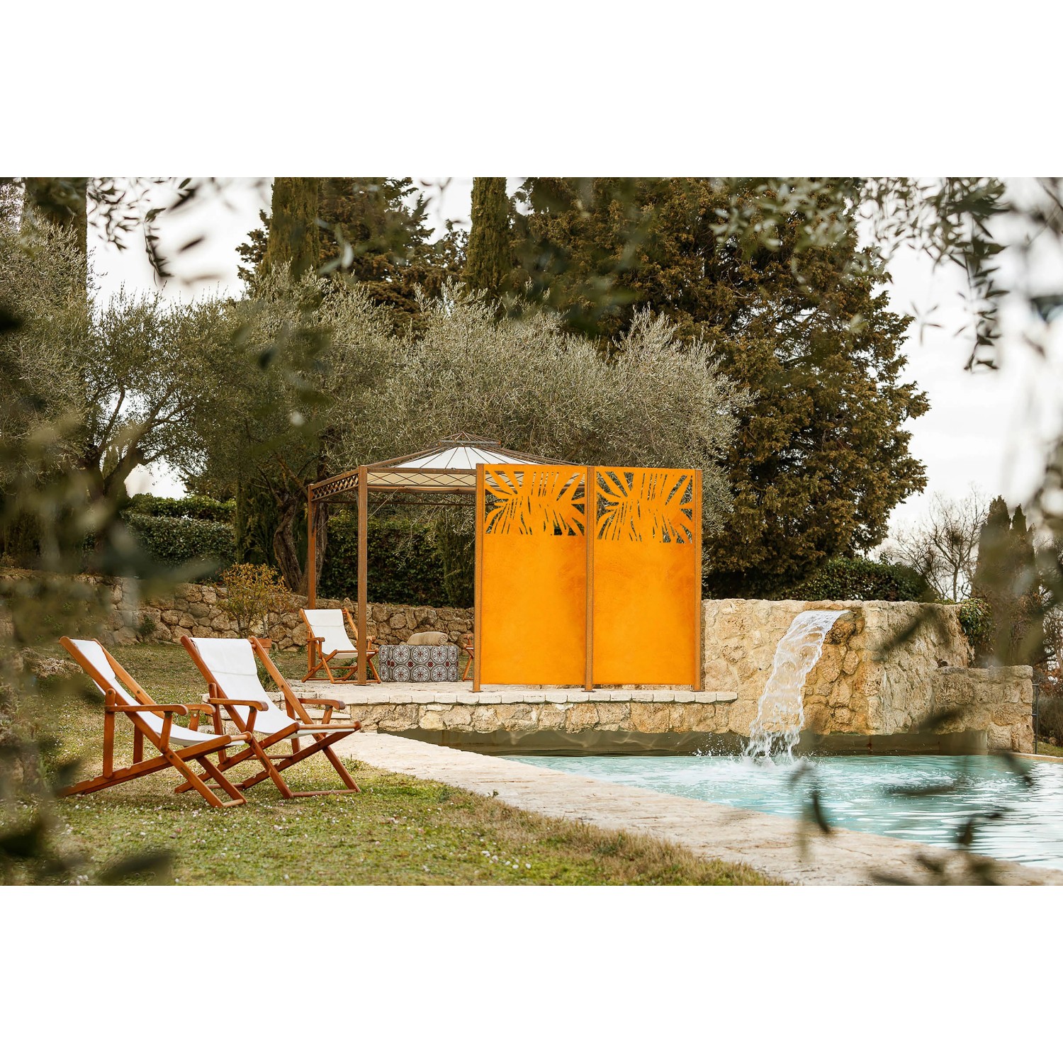 Eleo Sichtschutz Taro Cortenstahl mit Palmenmuster im Garten am Pool.