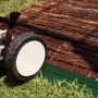 Foto eines Rasenmähers neben einer grünen Rasenkante und einer Beetumrandung aus Holz.