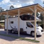 Holzbrüder Camping-Carport Ralf Natur mit dunkelgrauem Blechdach und Wohnmobil.