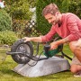 Mann pumpt Schubkarrenreifen mit Bosch Akku-Luftpumpe UniversalPump 18V auf.