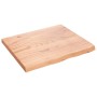 Helle, rechteckige Waschtischplatte aus behandeltem Massivholz (Eiche) mit Naturkante.