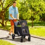 Mann schiebt PawHut Hundewagen mit Hund im Park. Faltbarer Transportwagen mit Netzfenster.