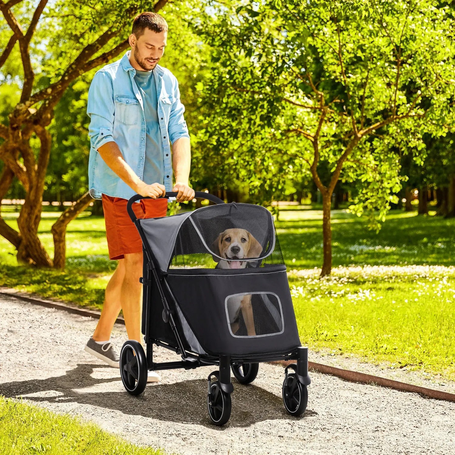Mann schiebt PawHut Hundewagen mit Hund im Park. Faltbarer Transportwagen mit Netzfenster.