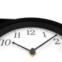 Nahaufnahme einer schwarz-weißen Bahnhofsuhr mit analogem Zifferblatt, schwarzen Zeigern und großen Zahlen. Wanduhr aus Metall.