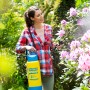 Frau nutzt Gloria Drucksprühgerät Primex 5 zur Pflanzenpflege im Garten.
