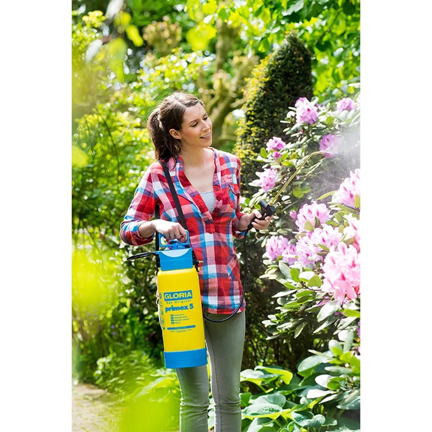 Frau nutzt Gloria Drucksprühgerät Primex 5 zur Pflanzenpflege im Garten.