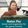 Mädchen mit Hund und Katze auf grünem KARAT Schaffell Audrey Thyme. Premium Lammfell für gemütliche Stunden.