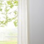 Mydeco Ösenschal Pure Ecru, 300x135 cm, halbtransparent, an Gardinenstange vor Fenster mit Ausblick.