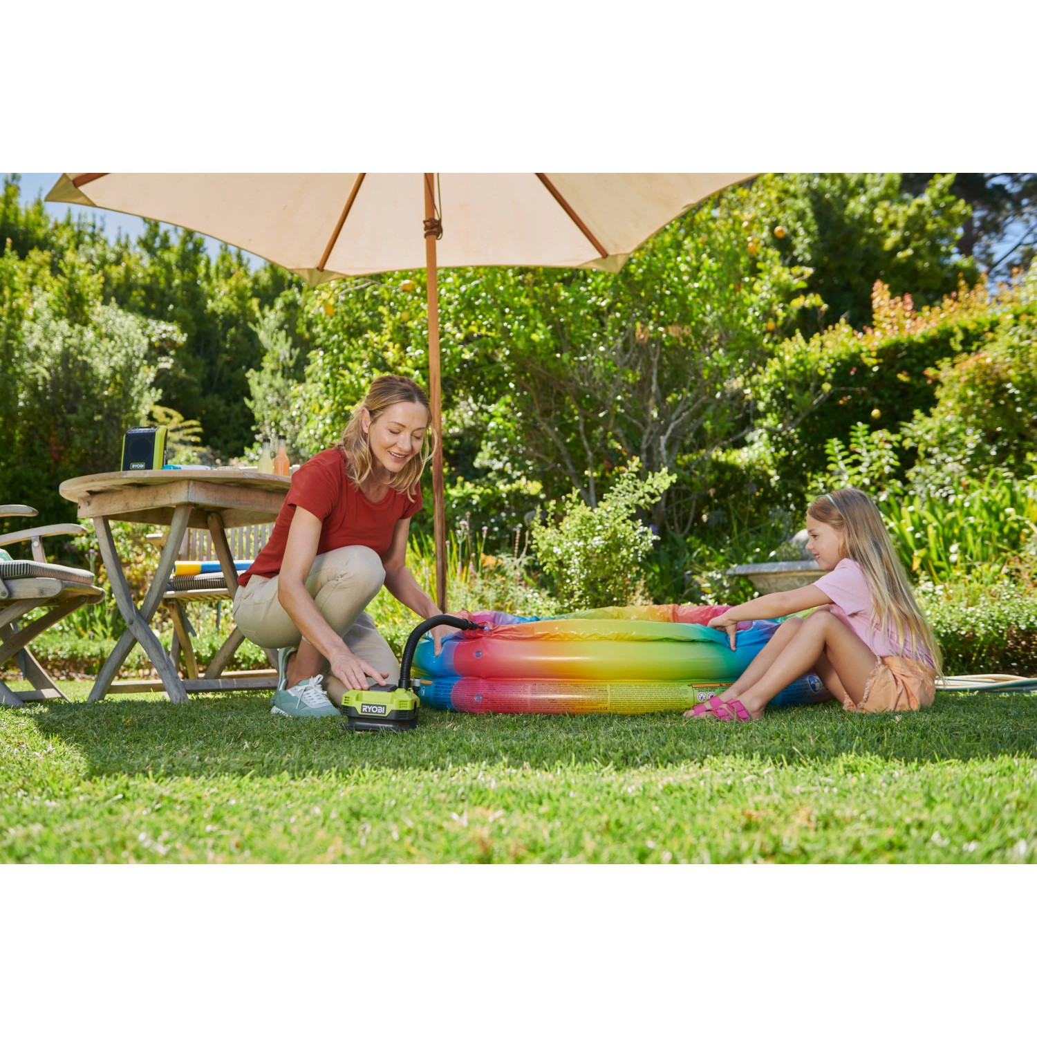 Ryobi Akku-Multi-Kompressor beim Aufpumpen eines Pools im Garten.