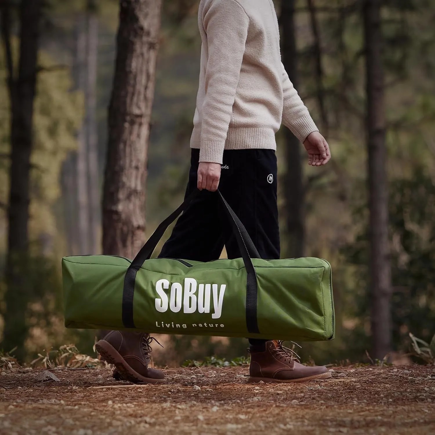 Person trägt grüne SoBuy Transporttasche für 2 Personen Feldbett mit Zelt im Wald.