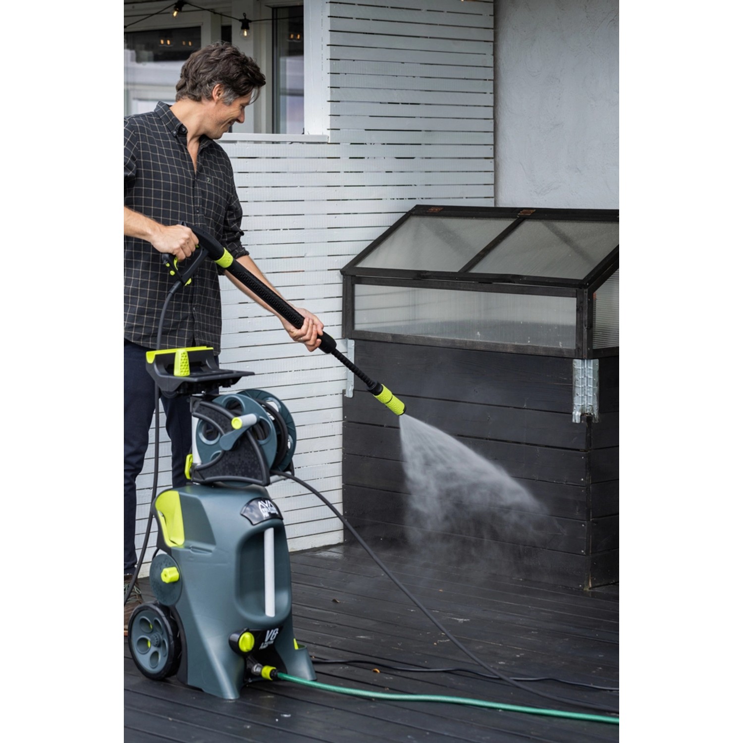 AVA Evolution P80 Hochdruckreiniger im Einsatz: Graues Gehäuse, Schlauchtrommel, Lanze mit Wasserstrahl.