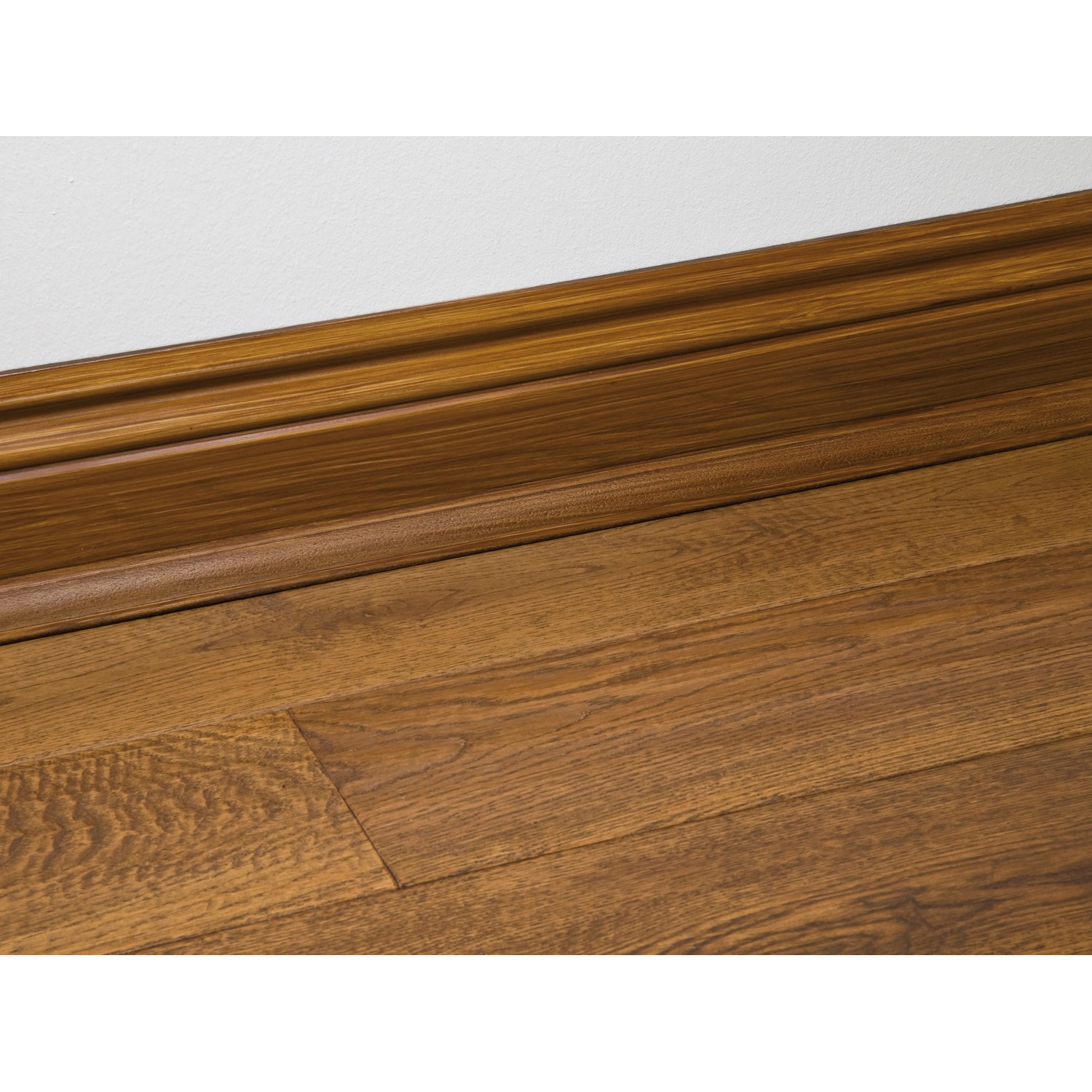 Holzfarbener D-Line Kabelkanal (22x22 mm) mit Holzfasern an Wand und Boden.