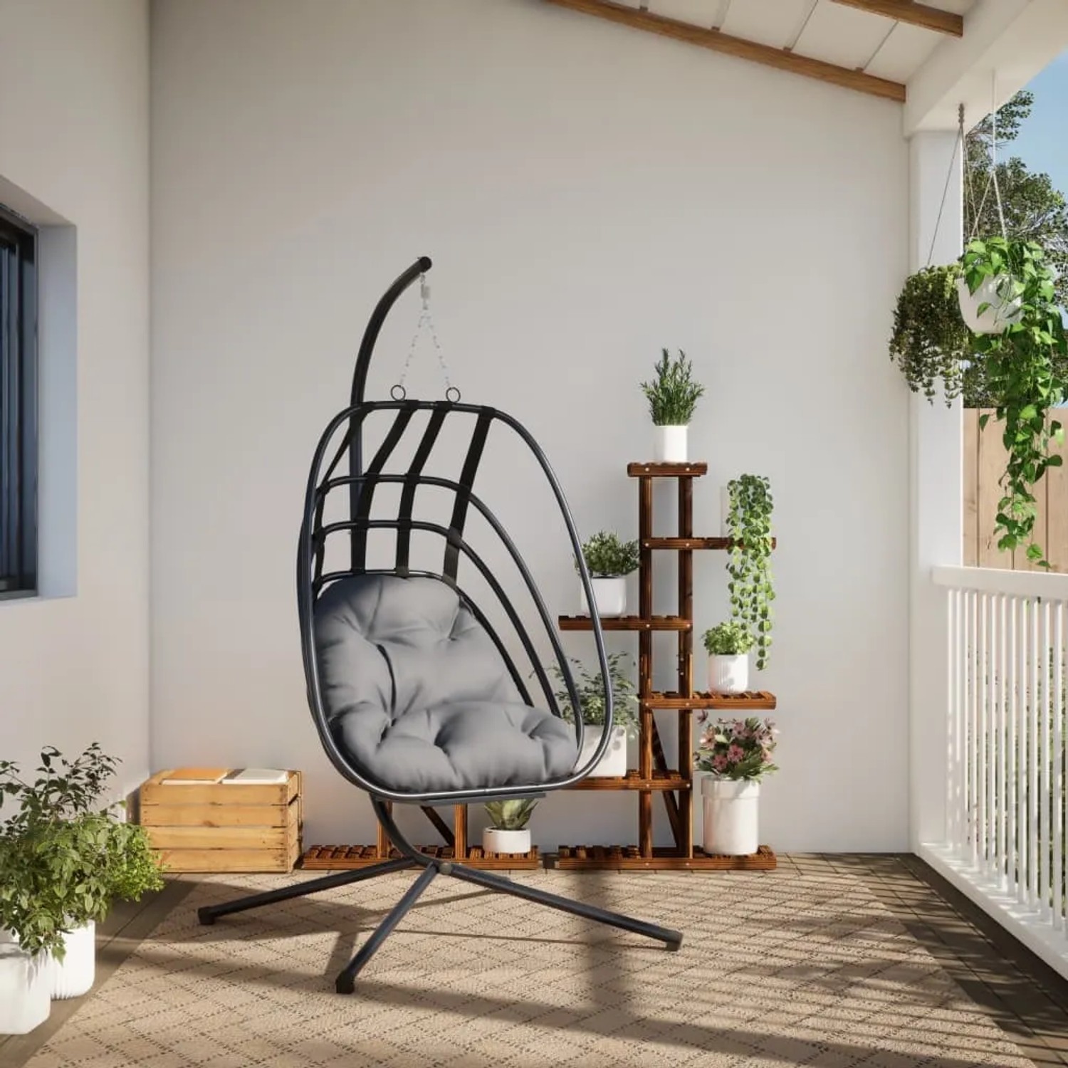 Anthrazitfarbener Hängesessel im Ei-Design mit Stahlgestell und grauem Kissen.