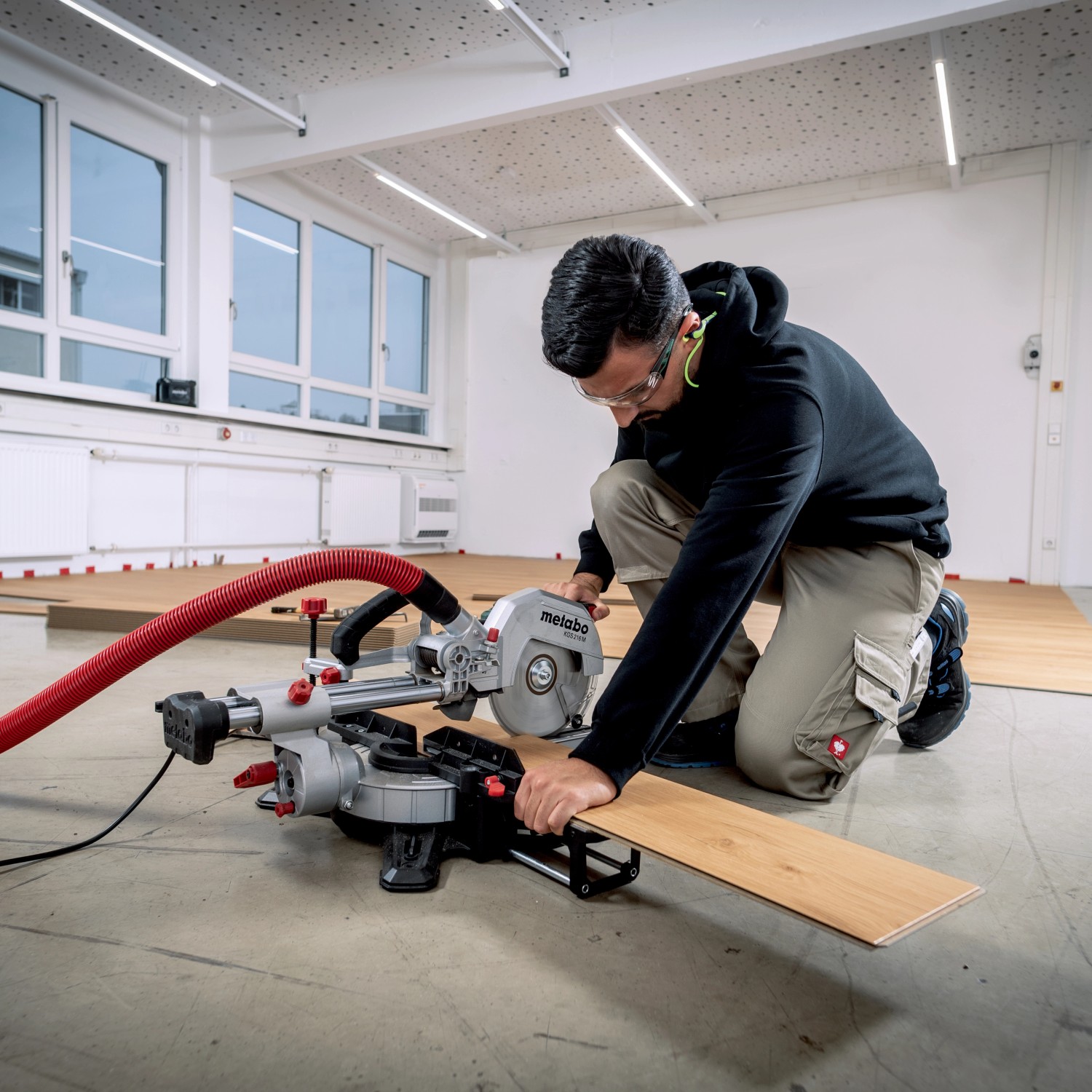 Mann schneidet Holz mit Metabo Kappsäge KGS 216 M Set. Zug-, Kapp- & Gehrungssäge im Einsatz.