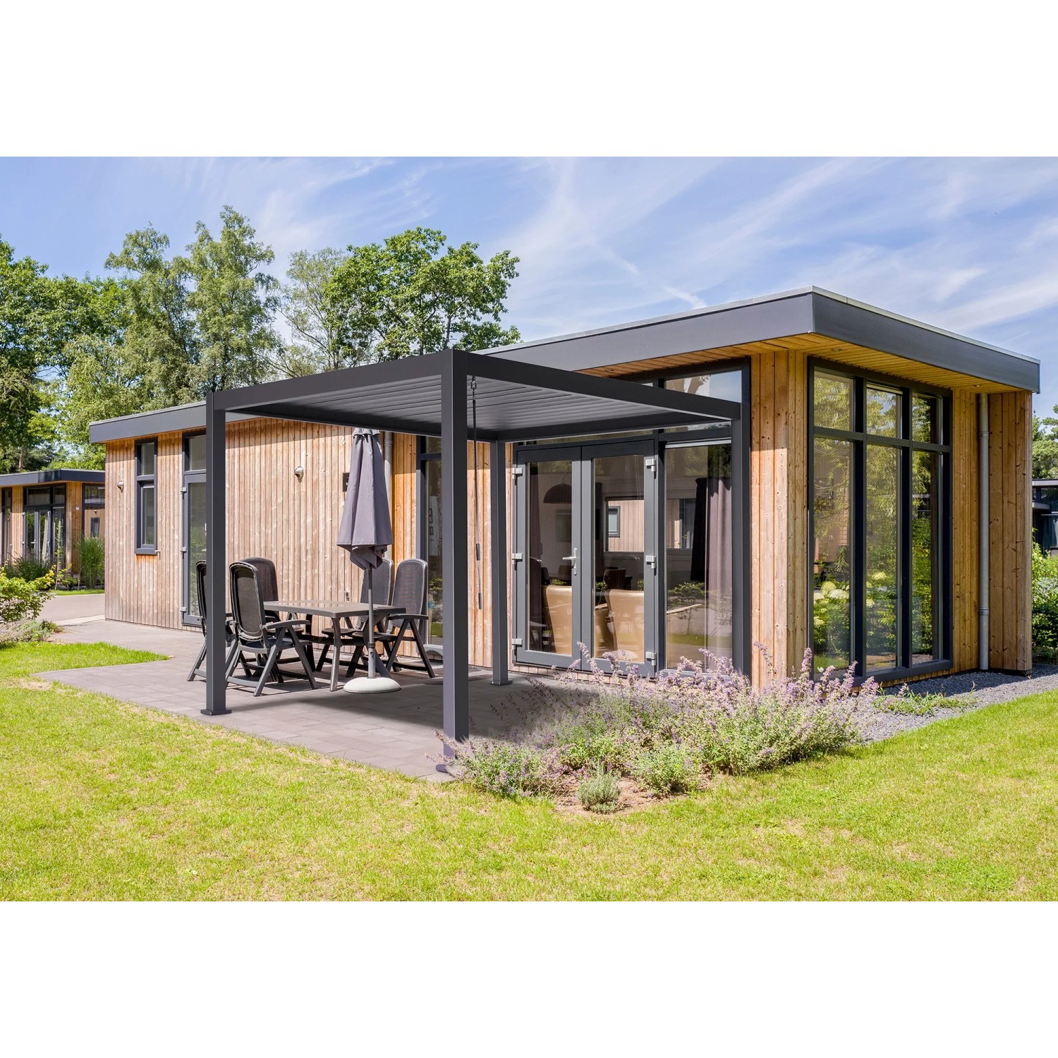 Best Cadiz Terrassenüberdachung 300x400 cm mit Lamellendach und Sitzgruppe im Garten.