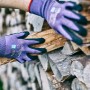 Gebol Multi Flex Lady Arbeitshandschuhe Größe 7 in Lila mit Holz in den Händen.