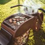 Ferrum Art Design Grillstelle Motorrad in Rostoptik mit Grillgut und Holzscheiten.