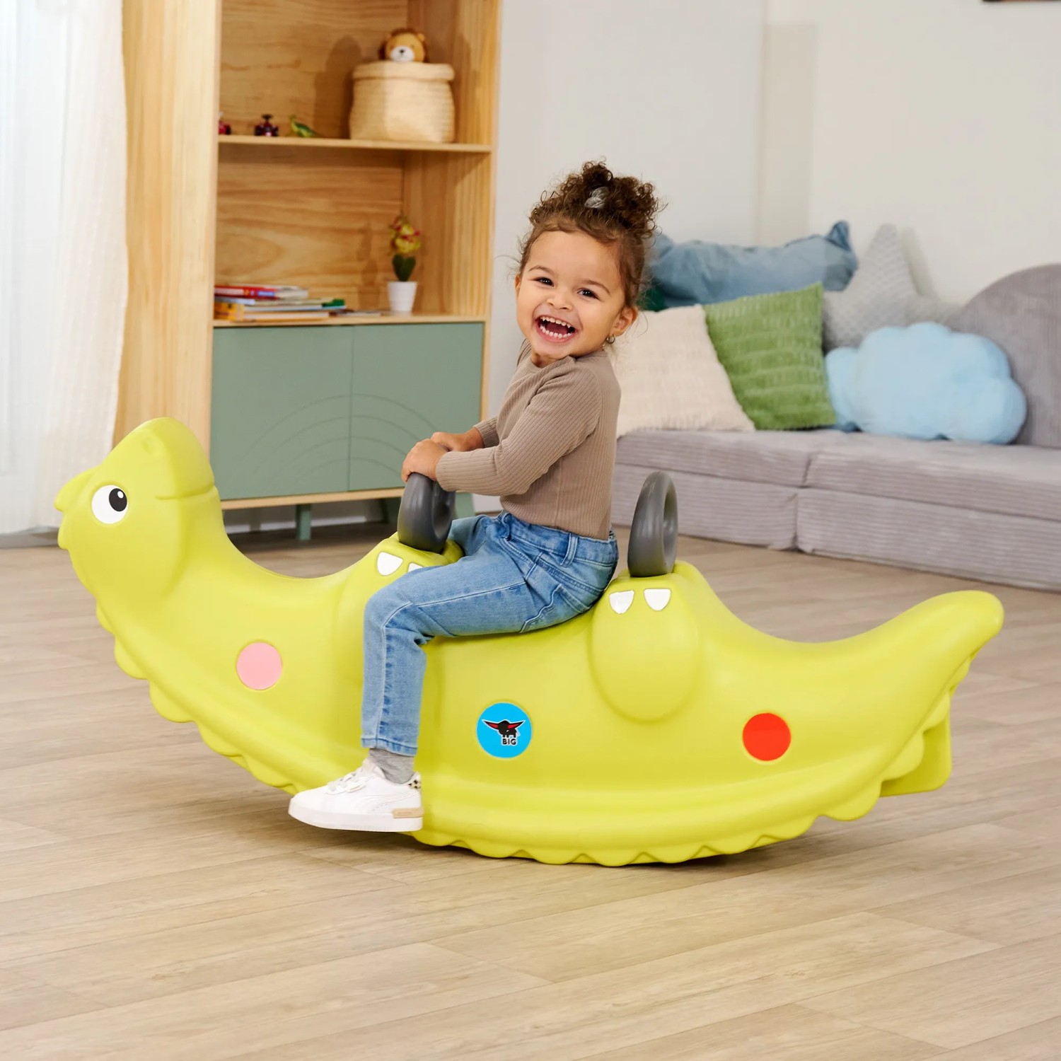 Kind auf grüner BIG Kinderwippe Sammy Rocker im Dinosaurier-Design. Spiel & Spaß für Kinder.