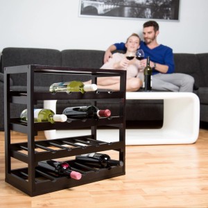 Schwarzes Echtholz Weinregal mit 4 Ebenen für Flaschen. Modernes Design im Wohnzimmer, Paar genießt Wein.