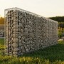 Rechteckige Gabione aus silbernem, feuerverzinktem Stahlgitter, gefüllt mit Steinen, auf grünem Rasen im Garten.