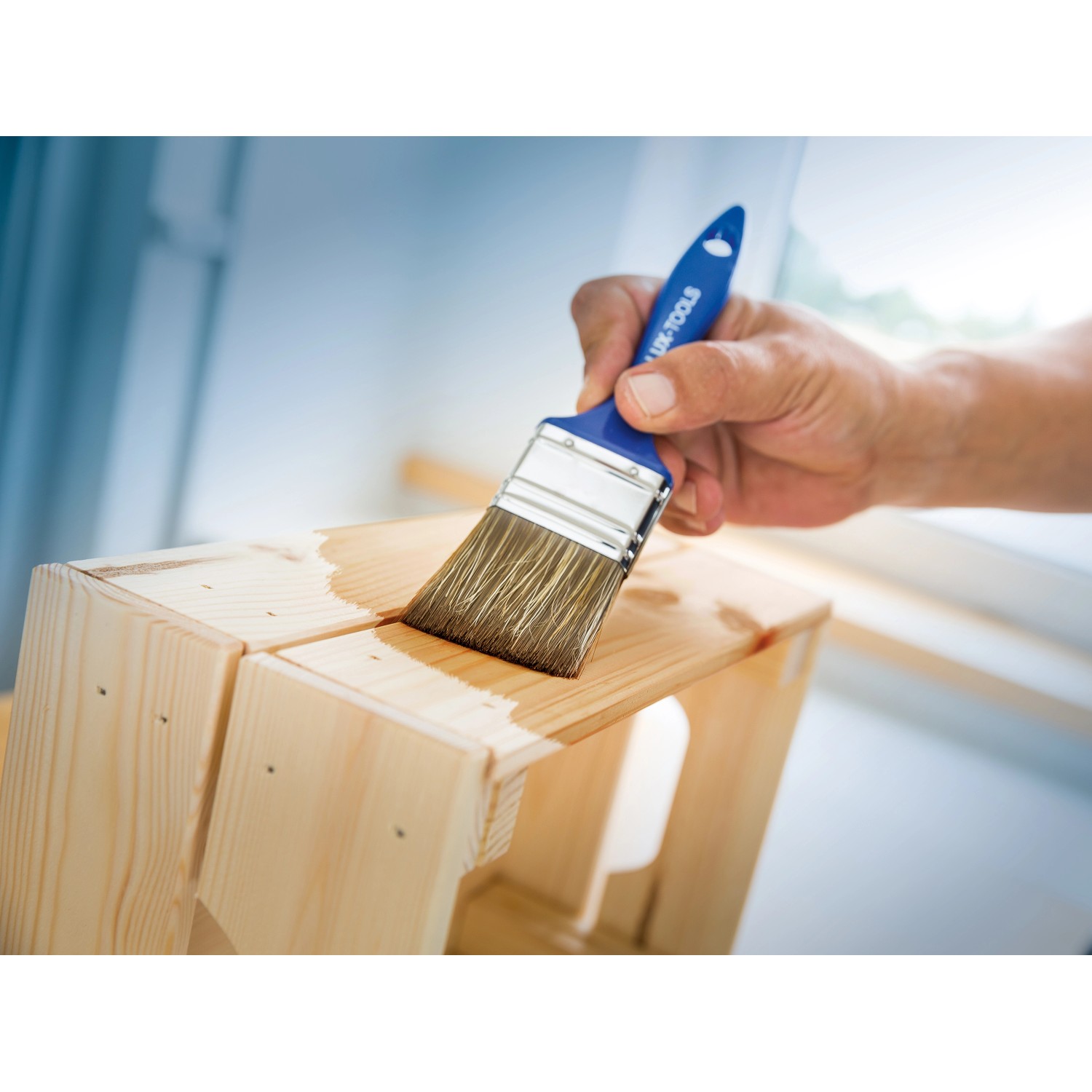 LUX Flachpinsel Lasur 50mm im Einsatz: Holz wird mit Lasur gestrichen.