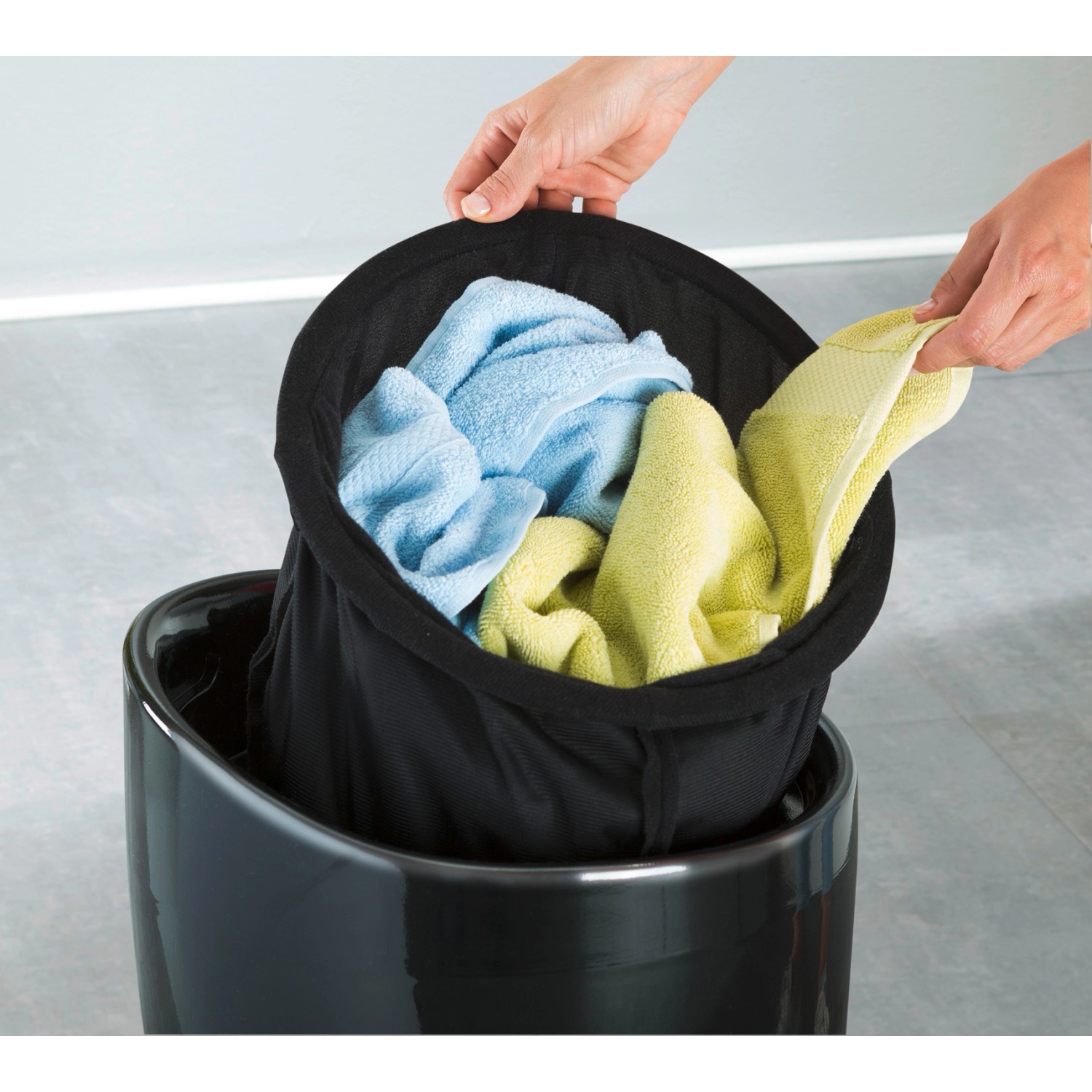 Schwarzer Wenko Badhocker Candy mit Wäschekorb (20L) und Handtüchern.