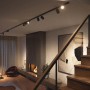 Schwarze Philips Hue Perifo LED-Spots an Schiene im Wohnraum mit Kamin und Treppe.