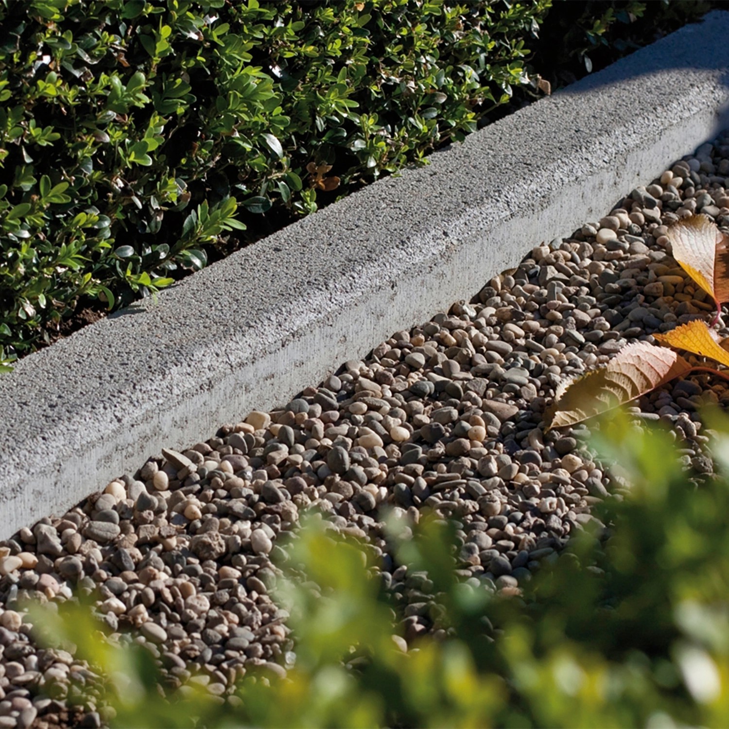 Grauer Tiefbordstein aus Beton (100x20x8 cm) zur Beet- und Wegeinfassung im Garten.