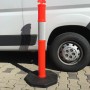 Oranger UvV FLEX Absperrpfosten mit Reflexstreifen und schwarzer Fußplatte.