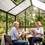 KGT Gewächshaus Galant III: Paar entspannt im tannengrünen Gartenhaus mit Hohlkammerplatten.