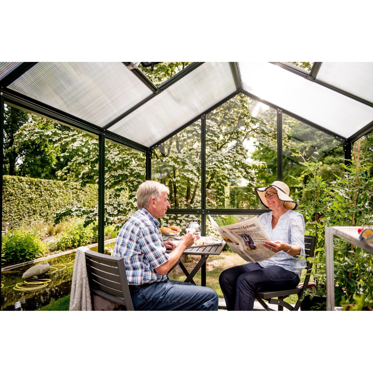 KGT Gewächshaus Galant III: Paar entspannt im tannengrünen Gartenhaus mit Hohlkammerplatten.