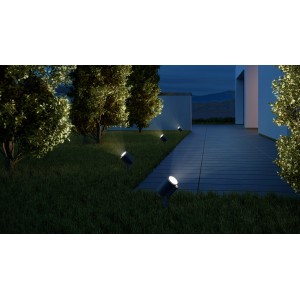 Anthrazitfarbene Steinel LED Gartenstrahler Spot Garden N beleuchten einen Gartenweg bei Nacht.