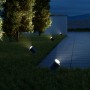 Anthrazitfarbene Steinel LED Gartenstrahler Spot Garden N beleuchten einen Gartenweg bei Nacht.