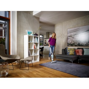 Frau saugt Teppich mit Leifheit Akku-Staubsauger Regulus PowerVac. Handstaubsauger mit Akku.