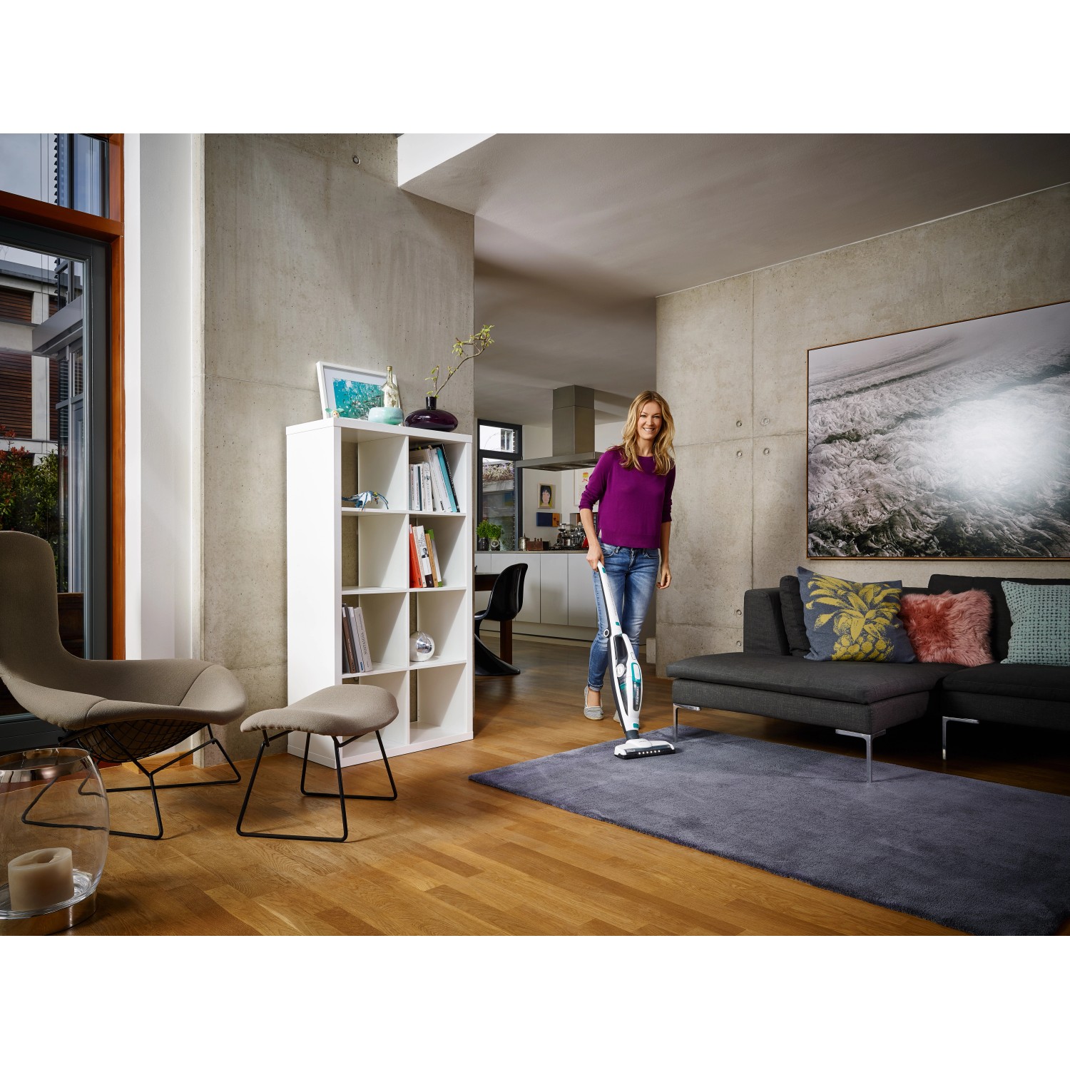 Frau saugt Teppich mit Leifheit Akku-Staubsauger Regulus PowerVac. Handstaubsauger mit Akku.