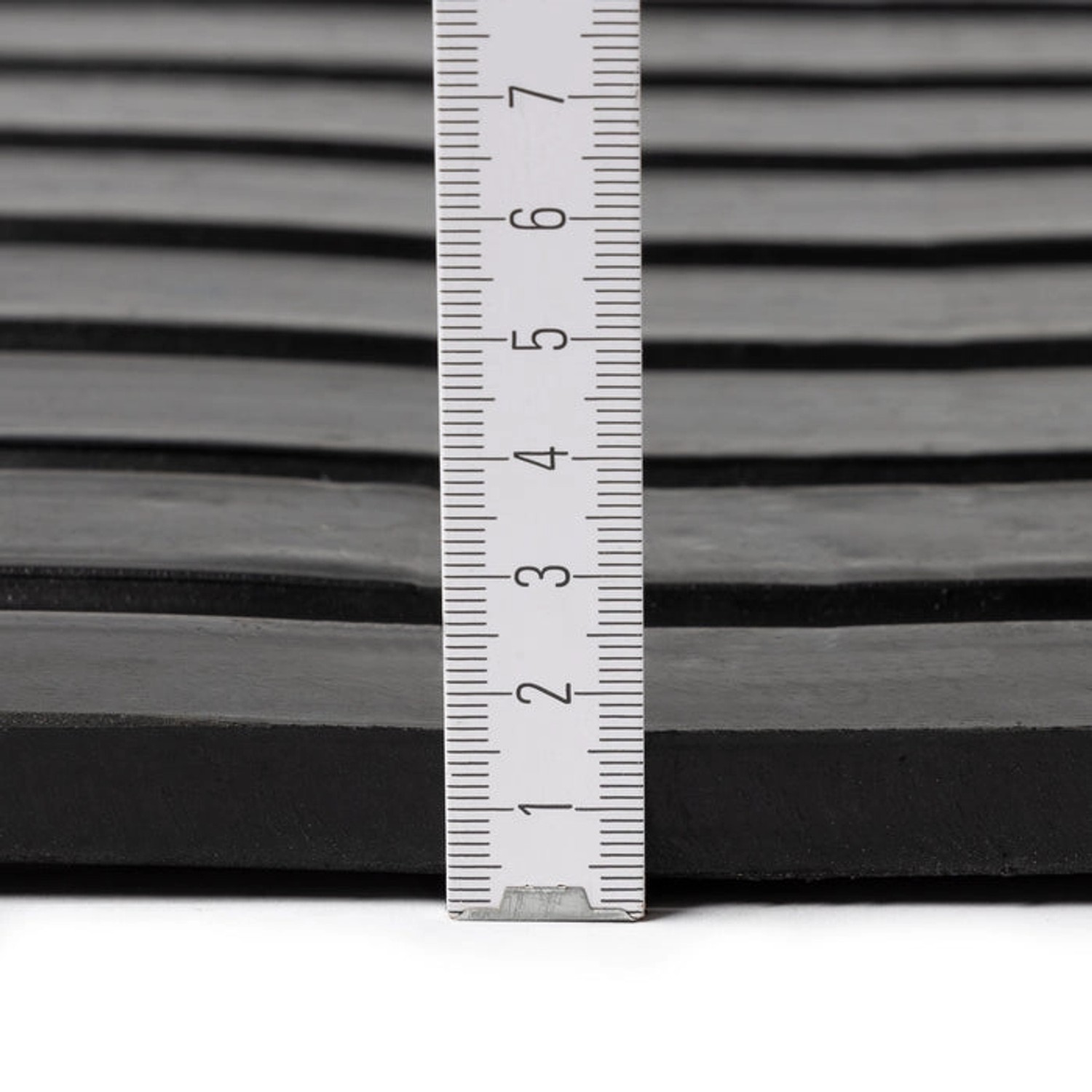 Detailaufnahme der KARAT Stallmatte Noppen. Drainagematte mit Messskala zur Verdeutlichung der Dicke.