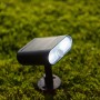 Lutec Ginbo LED Solar-Wandleuchte, schwarz, mit Bewegungsmelder, auf Rasen montiert.