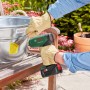 Bosch Akku-Heißluftgebläse EasyHeat 18V-500 beim Ablösen eines Etiketts im Garten.