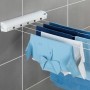 Wenko Wand-Wäscheleine, ausziehbar, weiß, mit Wäsche an grauer Wand. Praktischer Wäscheständer für Bad und Balkon.