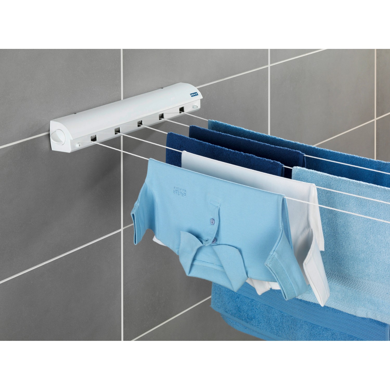 Wenko Wand-Wäscheleine, ausziehbar, weiß, mit Wäsche an grauer Wand. Praktischer Wäscheständer für Bad und Balkon.