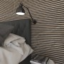Akustikpaneel Steinfurnier Tan an Wand hinter Bett mit Lampe. Dekoratives Wandpaneel.