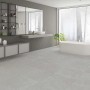 Badezimmer mit grauen, matten 60x60 Feinsteinzeug Bodenfliesen in Steinoptik.