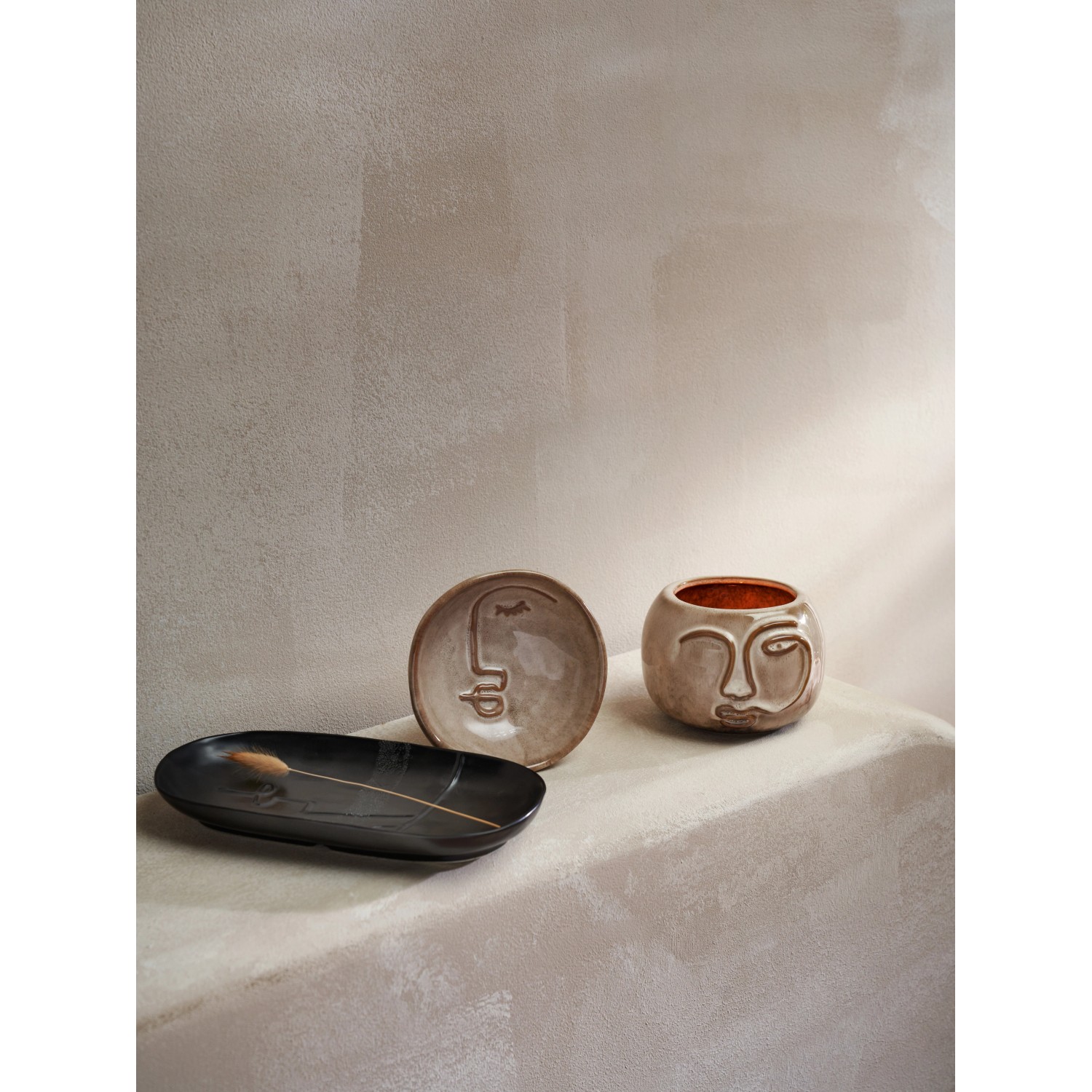 Dekorative Ancient Secret Schalen in Schwarz und Beige mit Gesichtsmotiven.