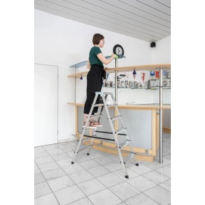 PROREGAL Haushaltsleiter, beidseitig begehbar, 2x4 Stufen, Aluminium, mit Person bei Reinigungsarbeiten.