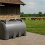 Grauer KMND 2000L Horizontal Wassertank für Trinkwasser auf gepflastertem Untergrund. Robustes PE-Material, ideal für Garten.