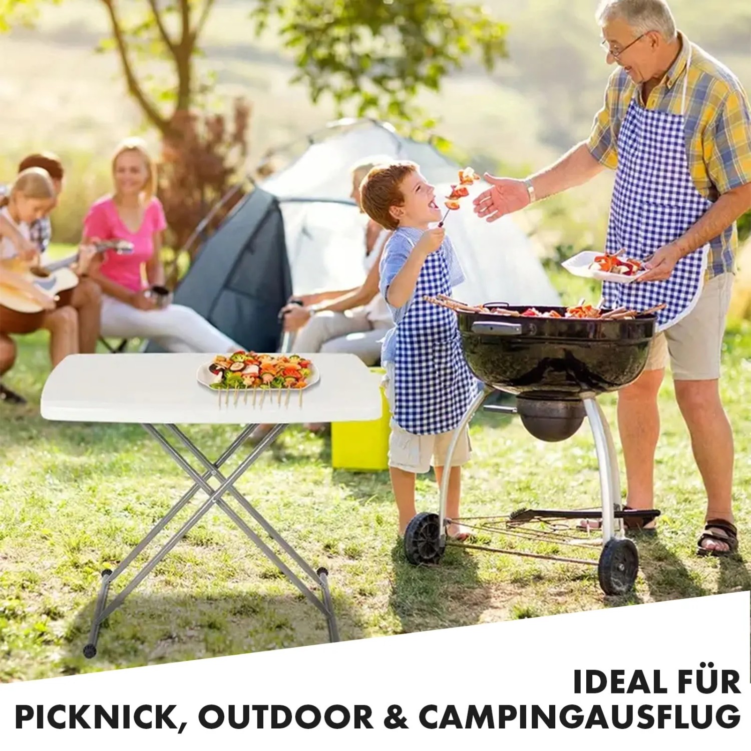 Weißer KARAT Klapptisch Nara im Garten beim Picknick mit Familie und Grill.