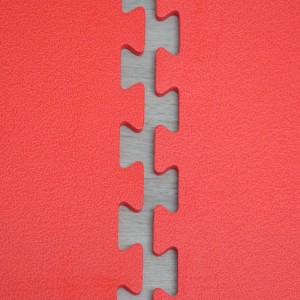 Detailaufnahme roter Puzzle-Trainingsmatten, verbunden. Strukturierte Oberfläche der Bodenschutzmatten für Fitness.