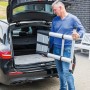 Zusammengeklappte Aluminium Teleskopleiter (11-stufig) wird aus einem Kofferraum gehoben.